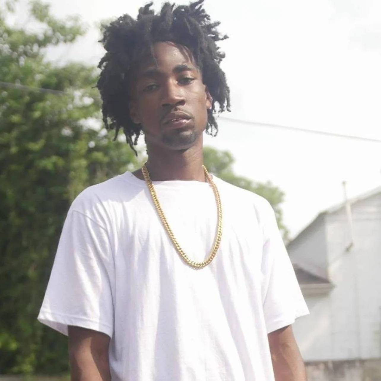 Keylo Da Beast outdoors in a white shirt and gold chain
