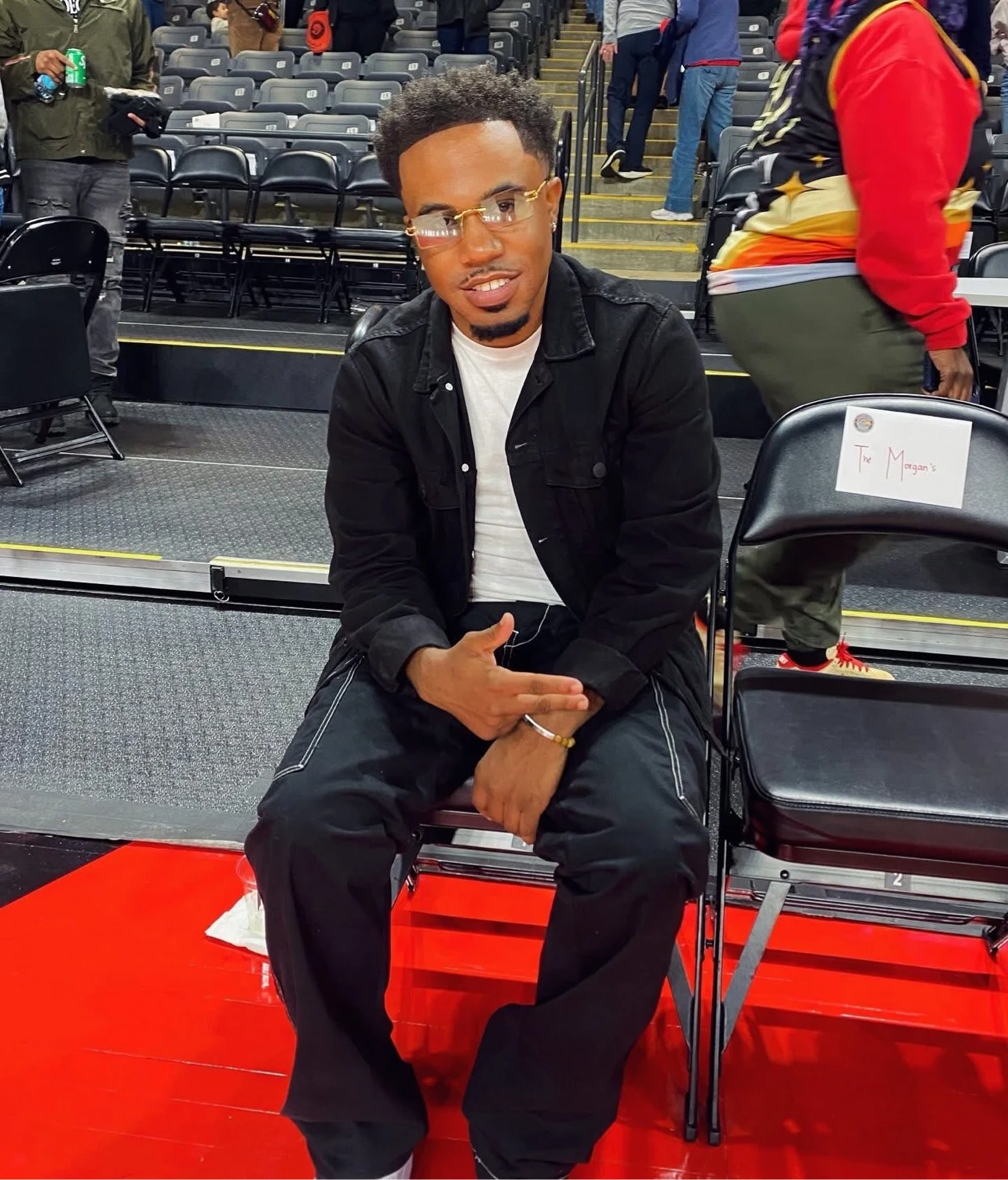 oNE Nuke seated courtside at an arena