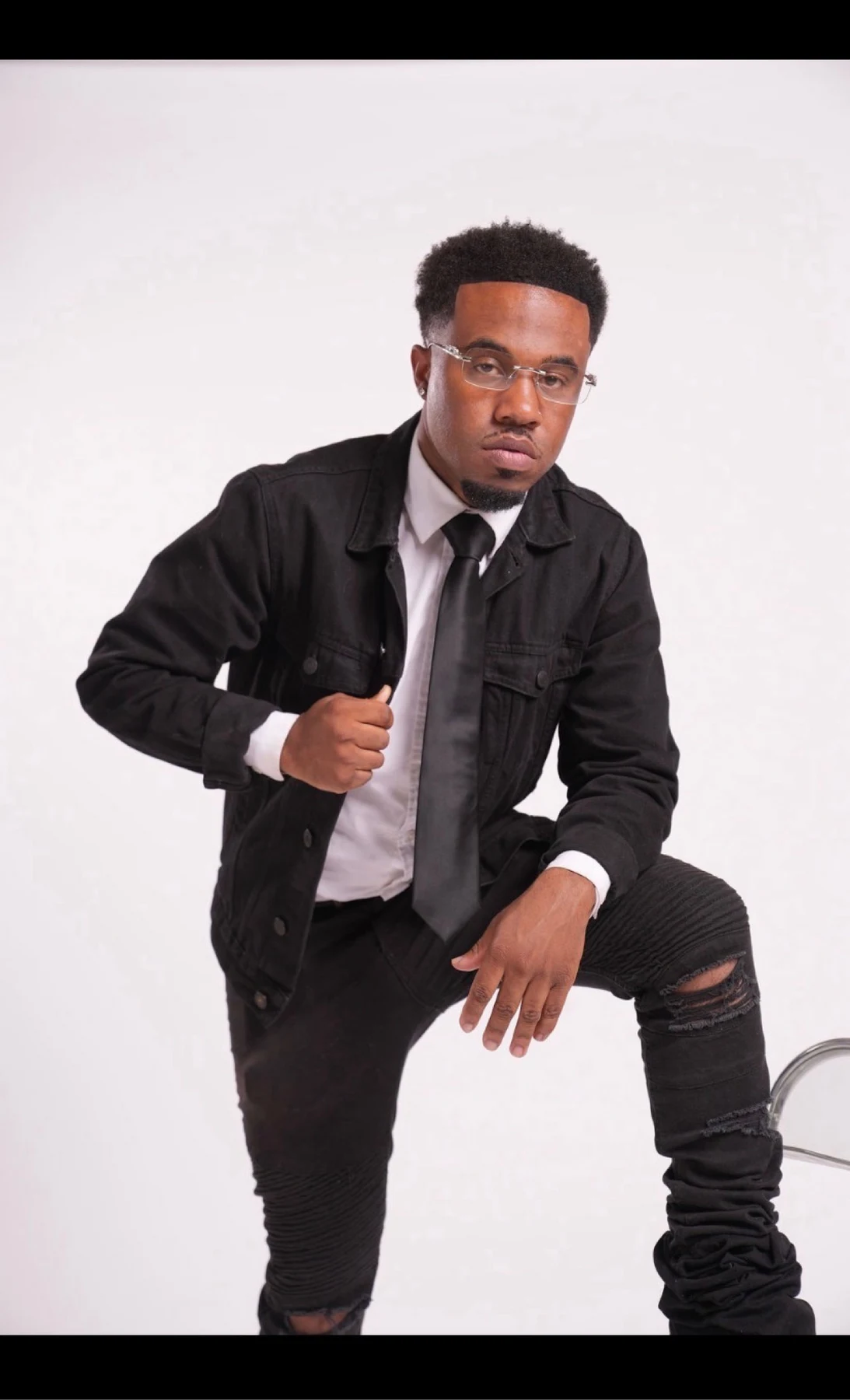 oNE Nuke in a black jacket leaning forward during a studio portrait session